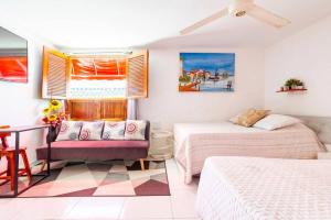 1 dormitorio con 2 camas, sofá y mesa en Casa Rachel en Cartagena de Indias