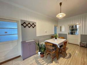 a kitchen with a table with chairs and a purple cabinet at Holiday home in Siofok - Balaton 19801 in Siófok