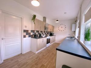 a large kitchen with a counter and a counter top at Group stays Wolverhampton M6 J10 in Bilston