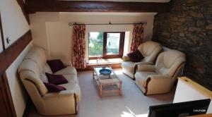 a living room with two couches and a table at The Hayloft, Broughton Beck, near Ulverston in Spark Bridge