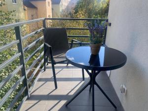 a glass table on a balcony with a vase of flowers at Černá růže - Apartmán 6 in Pilsen