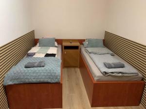 two twin beds in a room with a desk at Brookforest Apartman in Hajdúszoboszló