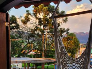 a hammock on a porch with a view of the mountains at PousaDinháChica Hospedagem perto de Tiradentes Minas in São João del Rei