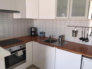 a kitchen with white cabinets and a sink at Magic Apartments in Quincy-Voisins