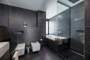 a bathroom with a tub and a toilet and a sink at Villa Luxury Sunrise Private Pool Corralejo By Holidays Home in Corralejo