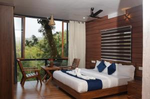 um quarto com uma cama grande e uma varanda em TREE6 WAYANAD em Vythiri