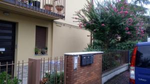 モデナにあるAlcova Nicolò Biondoの塀とピンクの花の木のある家
