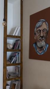 a painting of a man on a wall next to a book shelf at Hotel Urbano Ventia in Comodoro Rivadavia