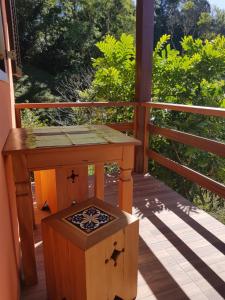 a wooden porch with a table and a box at Chalé mirante da colina in Visconde De Maua