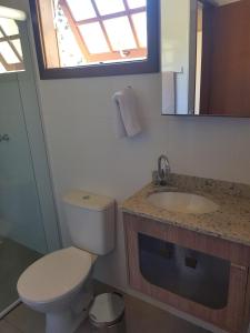 a bathroom with a toilet and a sink and a mirror at Chalé mirante da colina in Visconde De Maua +12 photos