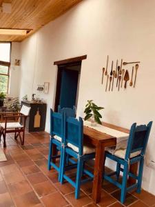 comedor con mesa de madera y sillas azules en Casa Abrigo, en Tocancipá