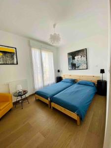 um quarto com uma grande cama azul num quarto em Magnifique appartement avec sa grande terrasse em Touques