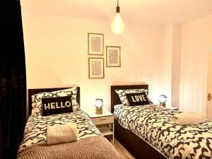 sypialnia z 2 łóżkami z poduszkami w obiekcie Modern Renovated 2-Bedroom House w mieście Barking