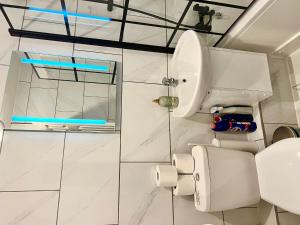 biała łazienka z toaletą i umywalką w obiekcie Modern Renovated 2-Bedroom House w mieście Barking