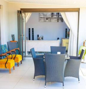 eine Terrasse mit Stühlen, einem Tisch und Stühlen in der Unterkunft Grace @ Rayton in Bloemfontein