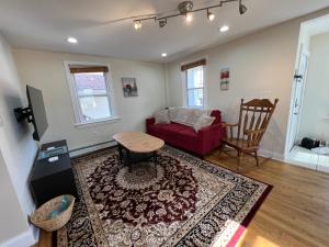 a living room with a red couch and a table at Bright & Spacious 1 BR- King Bed & Private Yard in Providence