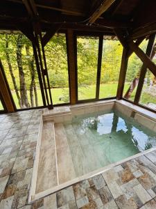 uma piscina interior numa casa com janelas em Cabana Verde em Budureasa