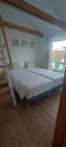 a large bed in a room with a ladder at Porto Pim Guest House in Horta