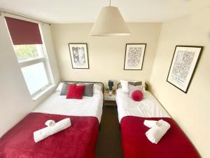 2 Betten in einem Zimmer mit roter und weißer Bettwäsche in der Unterkunft Group stays Wolverhampton M6 J10 in Bilston