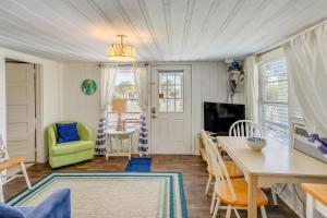 a living room with a table and a green chair at Coastal Cottage with Ocean View Walk to Pier in Myrtle Beach
