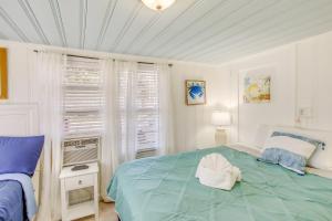 a bedroom with a bed with a white hat on it at Coastal Cottage with Ocean View Walk to Pier in Myrtle Beach
