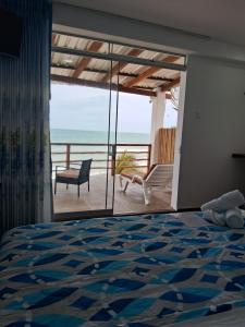 a bedroom with a bed and a view of the ocean at Las Fragatas Casa Hotel in Canoas de Punta Sal