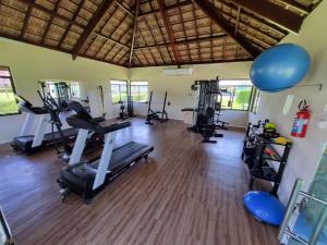 einen Fitnessraum mit Laufbändern und Trainingsgeräten in einem Zimmer in der Unterkunft Carneiros Beach Resort in Tamandaré