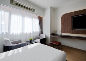 a hotel room with a bed and a flat screen tv at Panmanee Hotel-Newly Renovated in Phi Phi Don