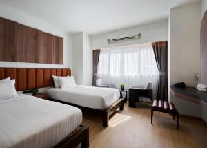 皮皮岛Panmanee Hotel-Newly Renovated的有两张床和一张书桌的酒店房间