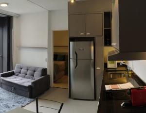 uma cozinha com um frigorífico e um sofá num quarto em VN Turiassu II em São Paulo