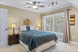 a bedroom with a bed with a ceiling fan and a window at Sanctuary House - a Wooded Retreat in Hot Springs
