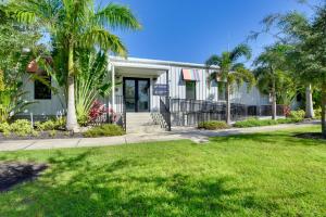 薩拉索塔的住宿－Sunlit Sarasota Cottage with Screened Porch!，庭院前有棕榈树的房子