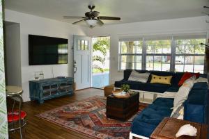 a living room with a blue couch and a tv at Tropical Retreat Near Beaches, Cruise Terminals in Merritt Island