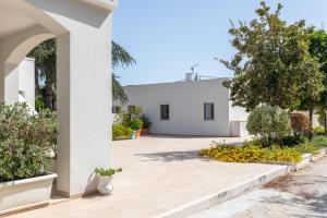 a white house with a courtyard with flowers at Luoghi di Puglia in Ostuni