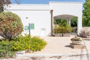 a white building with flowers in front of it at Luoghi di Puglia in Ostuni