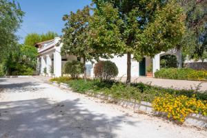 uma casa com uma árvore e flores à frente dela em Luoghi di Puglia em Ostuni