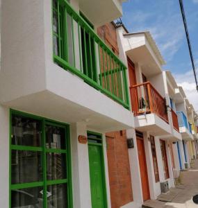 a building with green doors and a balcony at Orquidia 12 in Salento