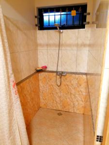 a shower in a bathroom with a window at Sand Castle Villa in Trou aux Biches