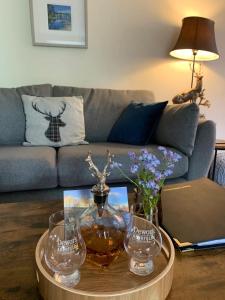 uma sala de estar com uma mesa e dois copos de vinho em Ivy Cottage, Aberfeldy - Highland Perthshire em Aberfeldy