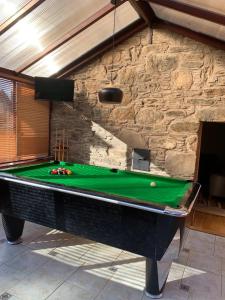 a pool table in front of a stone wall at Ivy Cottage, Aberfeldy - Highland Perthshire in Aberfeldy