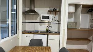 a small kitchen with a sink and a microwave at Apartamentos Mayor Centro in Madrid