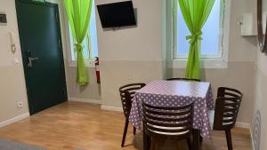 une table avec des rideaux verts et une table avec des chaises dans l'établissement Apartamentos Mayor Centro, à Madrid