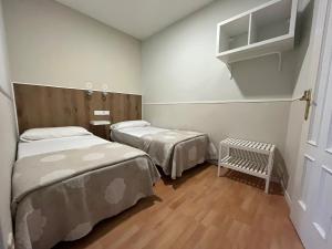 マドリードにあるApartamentos Mayor Centroのベッド2台とベビーベッド1台が備わる小さな客室です。