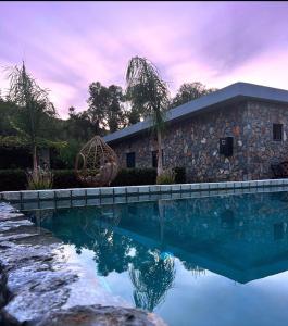 a stone house with a swimming pool in front of it at Aithonas Villa in Archangelos