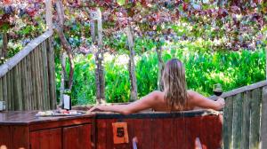 Cava Colchagua Hotel Boutique في سانتا كروز: امرأة في حوض الاستحمام مع كوب من النبيذ