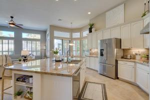 a large kitchen with white cabinets and a large island at Luxe Scottsdale Retreat Pool, Hot Tub and More! in Phoenix