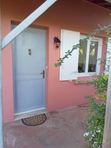 a pink house with a white door and windows at Maison 2 pièces, 4 personnes in Le Loroux-Bottereau