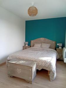 a bedroom with a bed and a blue wall at Maison 2 pièces, 4 personnes in Le Loroux-Bottereau