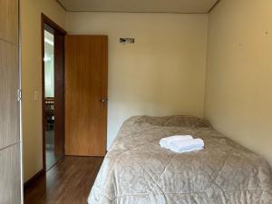 Cama o camas de una habitación en Apt Centro Gramado com Churrasqueira
