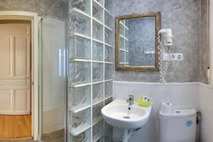 a bathroom with a sink and a mirror and a toilet at Apartamentos Mayor Centro in Madrid +140 photos
